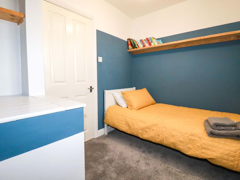 A bedroom with a bed and bookshelf at Trelowen in Trenance