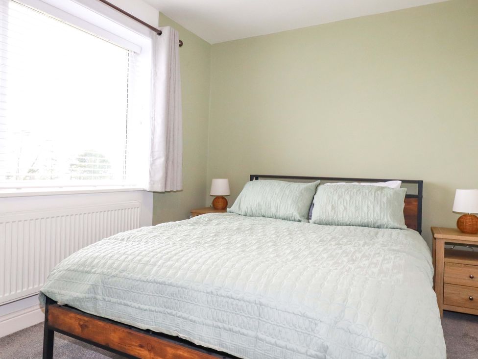 A bedroom with a bed and bedside tables at Trelowen in Trenance