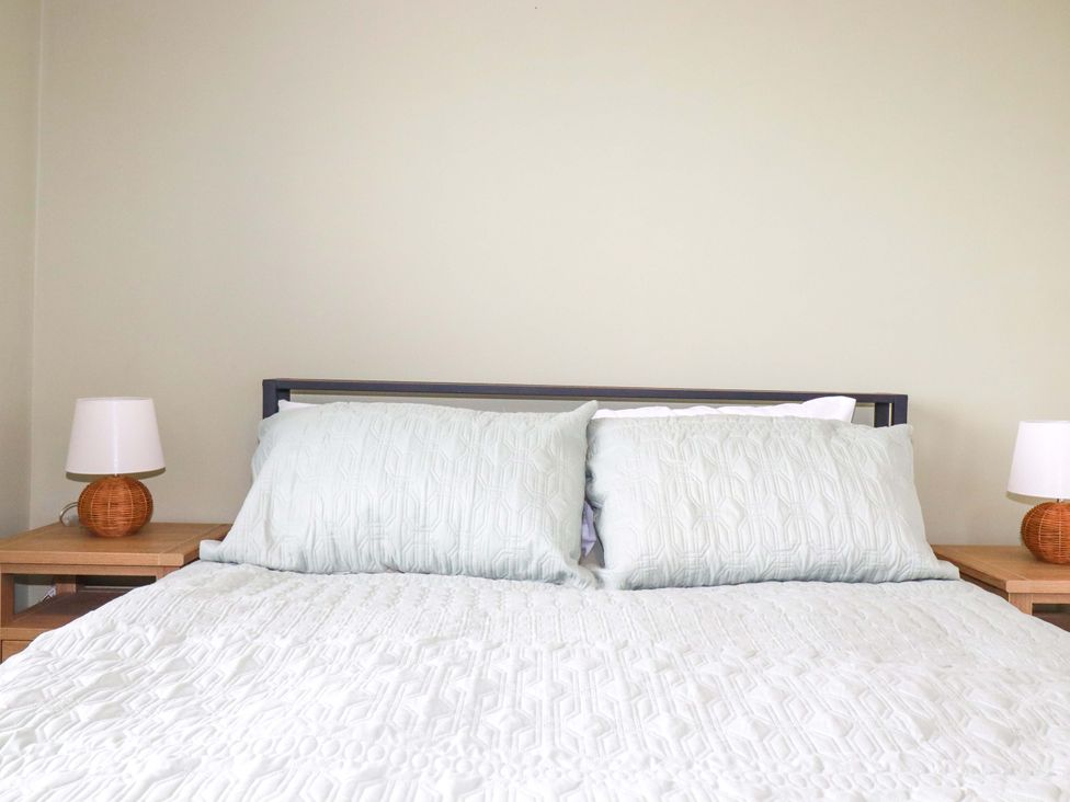 A bedroom with a bed and two lamps at Trelowen in Trenance