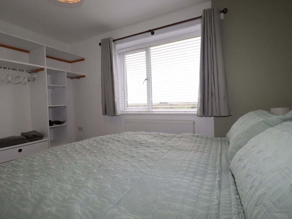 A bedroom with a bed and shelves at Trelowen in Trenance