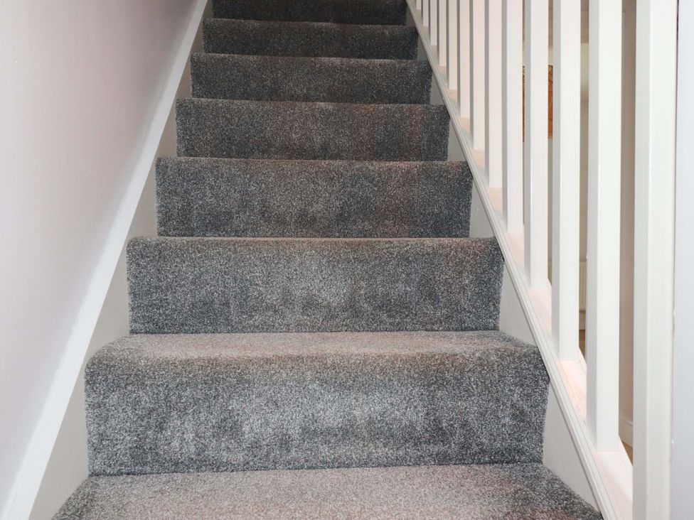 A staircase with carpet and railing at Trelowen in Trenance