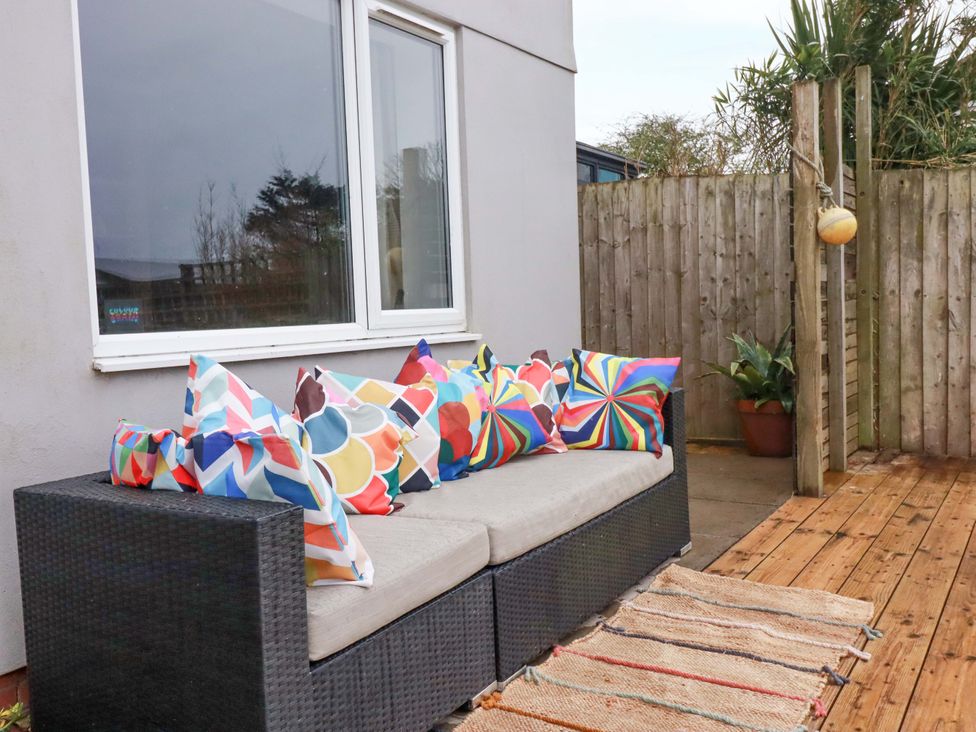 An outdoor seating area with a couch and colorful cushions at Trelowen in Trenance