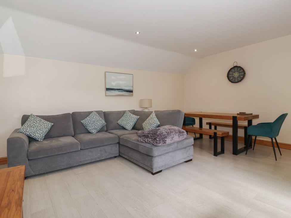 A living room with a sofa and dining table at Daisy Nook in Withernsea