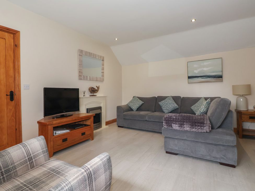 A living room with a sofa and television at Daisy Nook in Withernsea