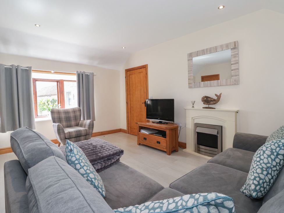 A living room with a sofa and television at Daisy Nook in Withernsea