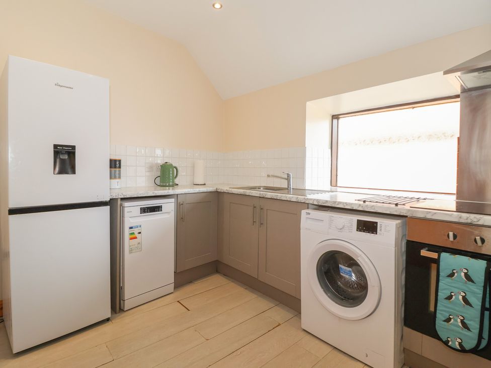 A kitchen with appliances including a refrigerator and washing machine at Daisy Nook in Withernsea