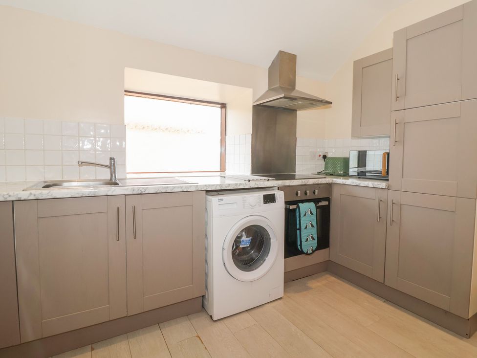 A kitchen with a washing machine and countertop at Daisy Nook in Withernsea
