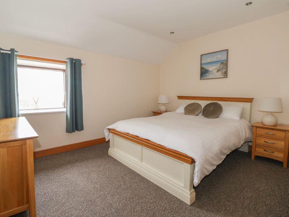 A bedroom with a bed and bedside tables at Daisy Nook in Withernsea