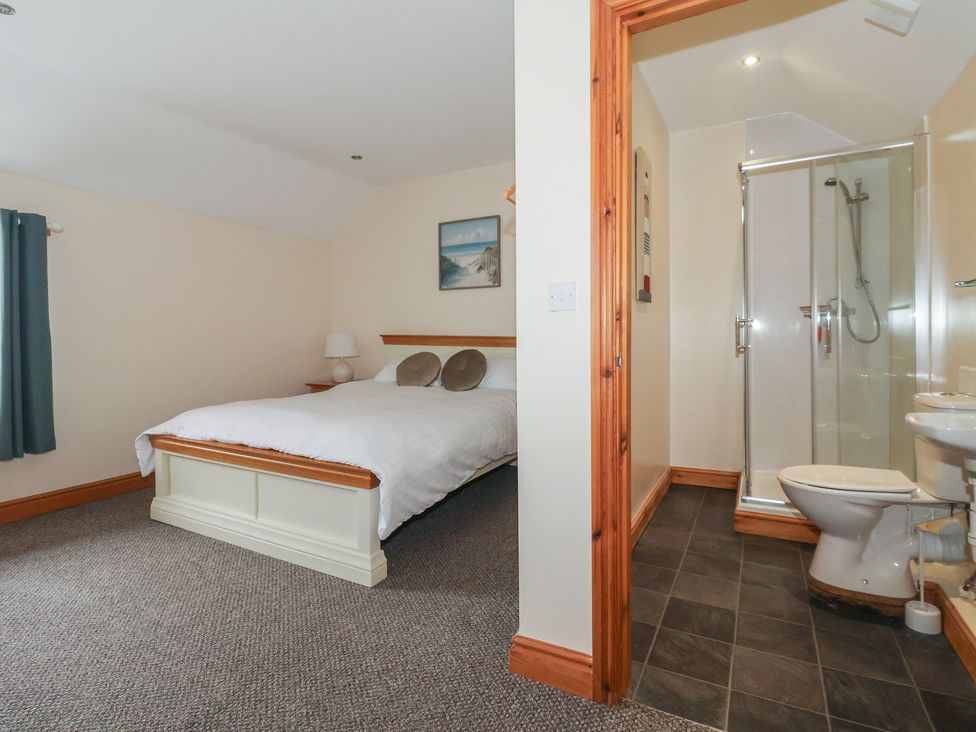 A bedroom with a bed and an adjoining bathroom at Daisy Nook in Withernsea