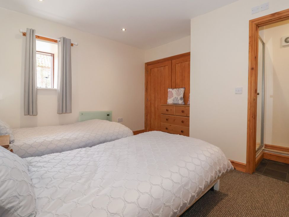 A bedroom with two beds and a wardrobe at Daisy Nook in Withernsea
