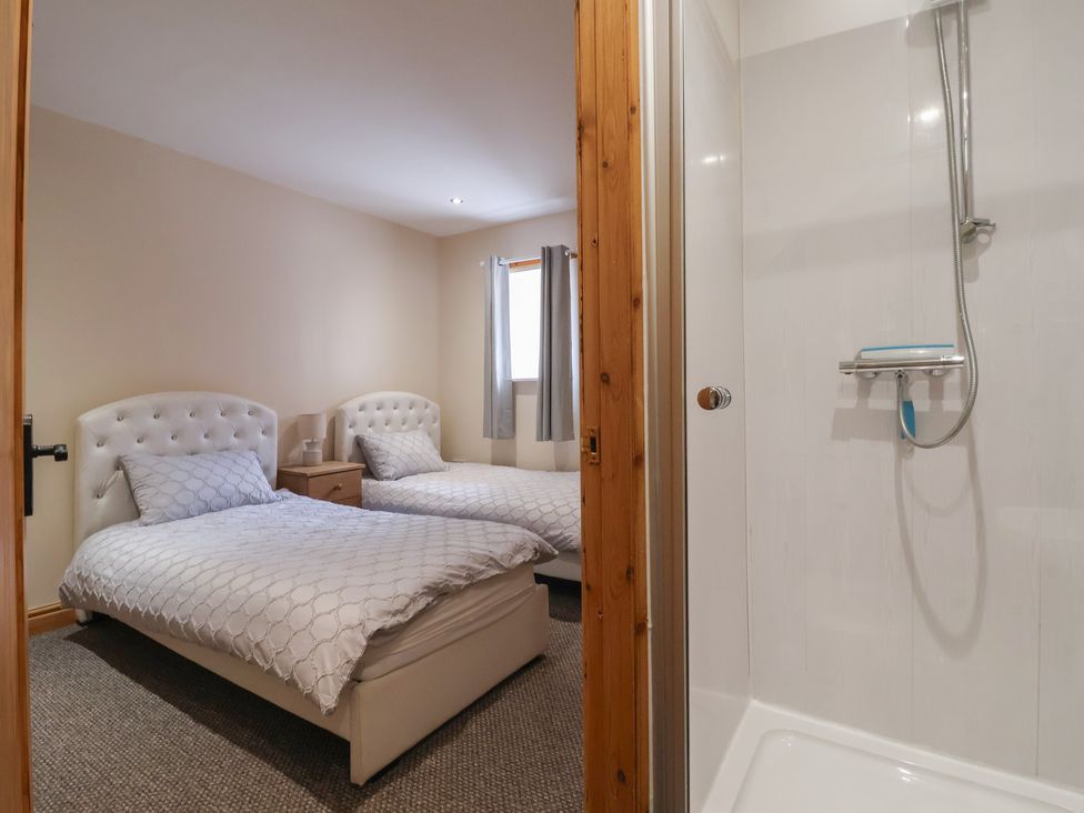 A bedroom with two beds and a shower at Daisy Nook in Withernsea