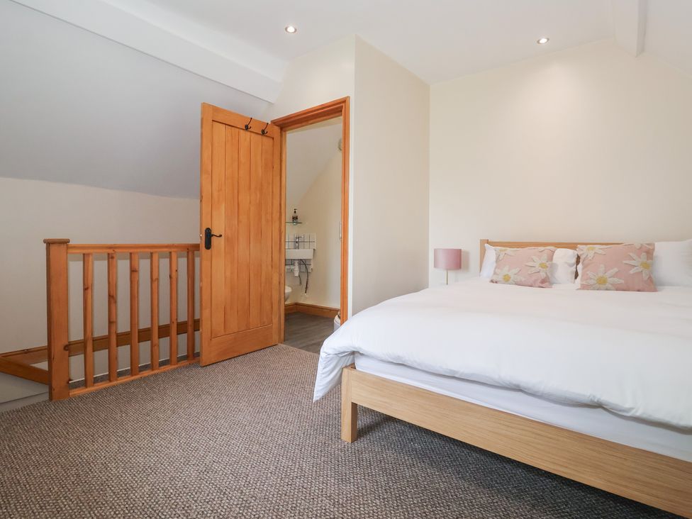 A bedroom with a bed and an adjacent bathroom door at Daisy Nook in Withernsea