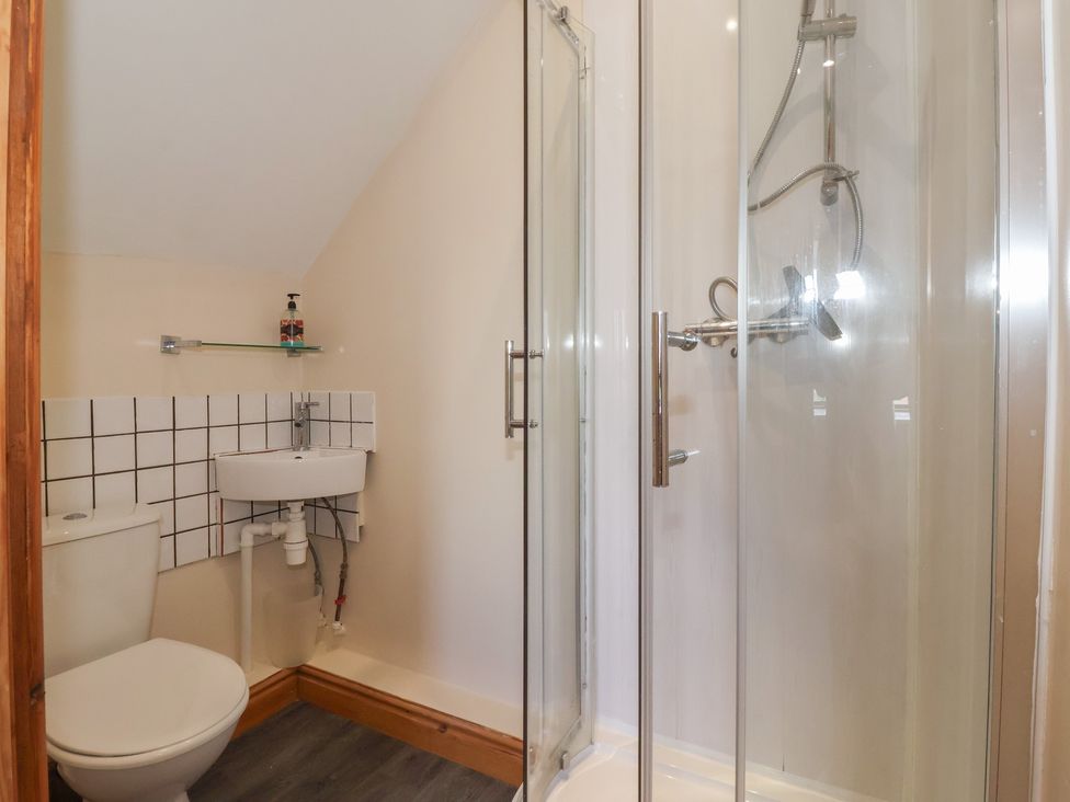 A bathroom with a shower, sink and toilet at Daisy Nook in Withernsea