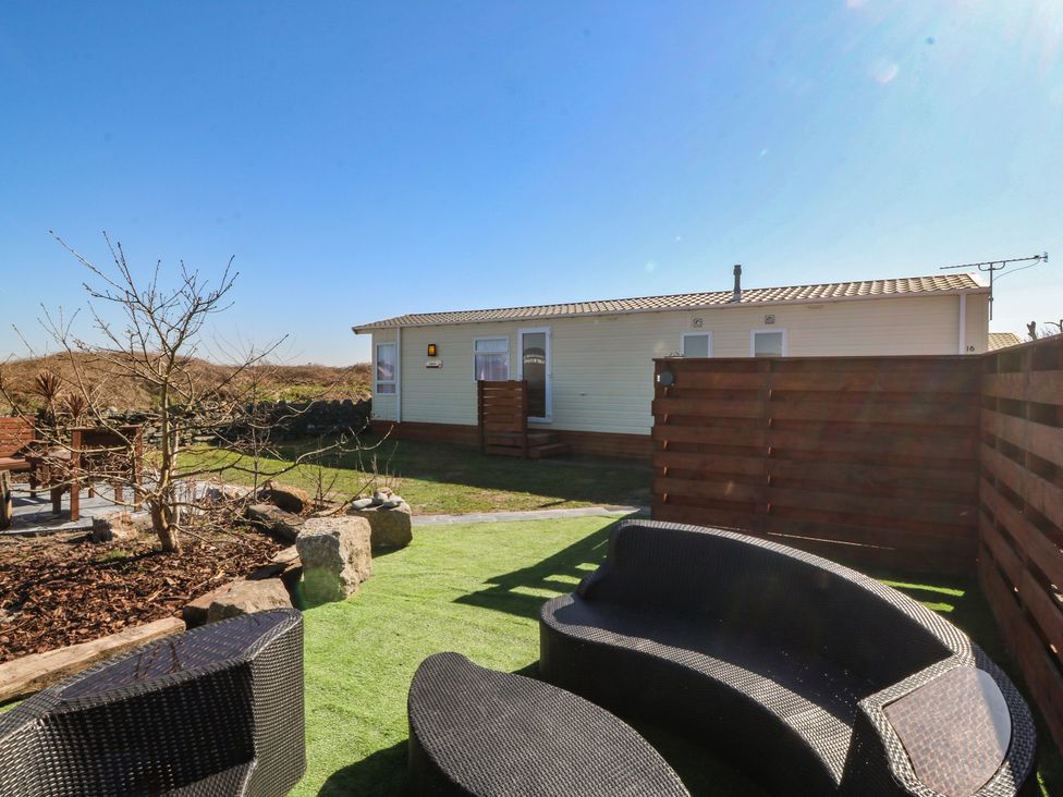 A garden with seating area and pathway at Pheasant Lodge in Holyhead