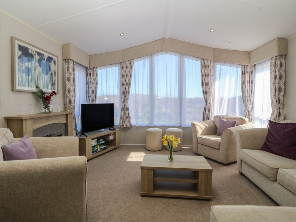 A living room with sofas and a television at Pheasant Lodge in Holyhead