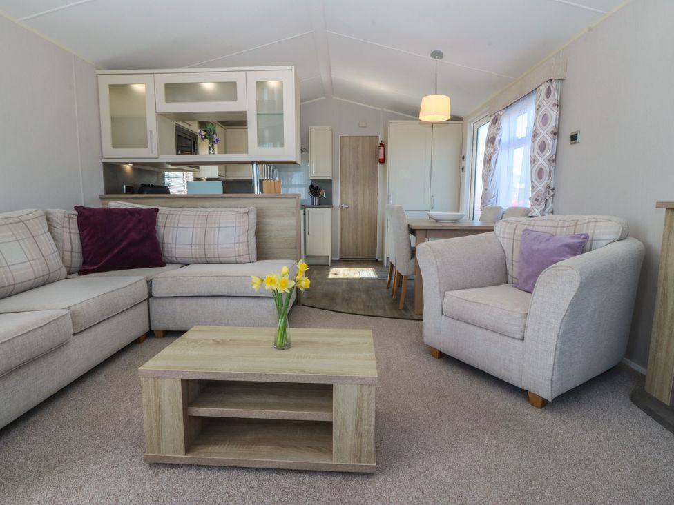 A living room with seating and table at Pheasant Lodge in Holyhead