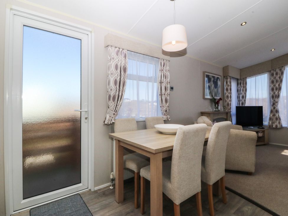 A dining room with a table and chairs at Pheasant Lodge in Holyhead