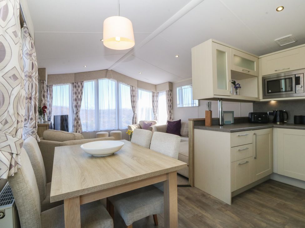 A living room with a dining table and sofa at Pheasant Lodge in Holyhead