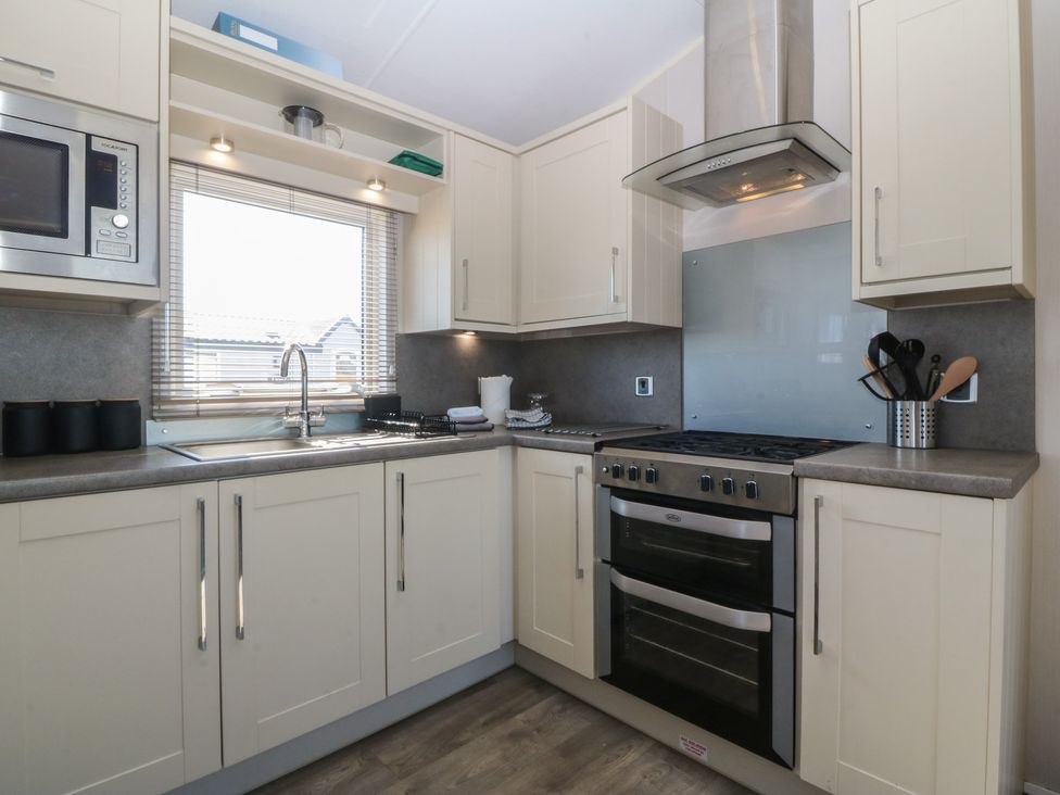 A kitchen with a sink and oven at Pheasant Lodge in Holyhead