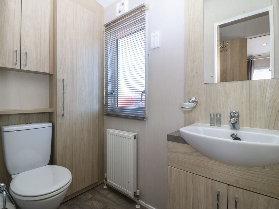 A bathroom with a toilet and sink at Pheasant Lodge in Holyhead