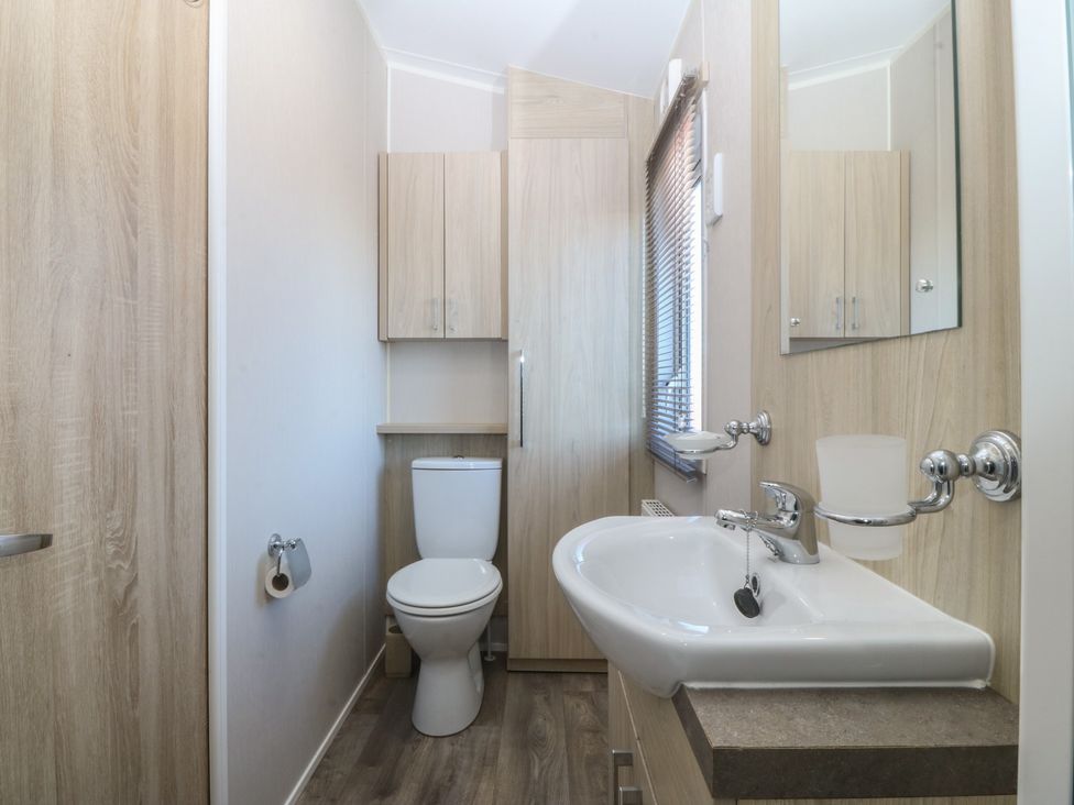 A bathroom with a toilet and sink at Pheasant Lodge in Holyhead