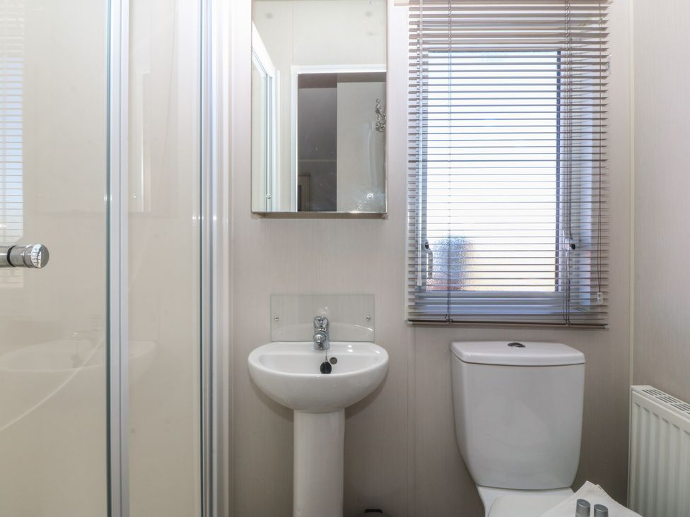 A bathroom with shower and sink at Pheasant Lodge Holyhead