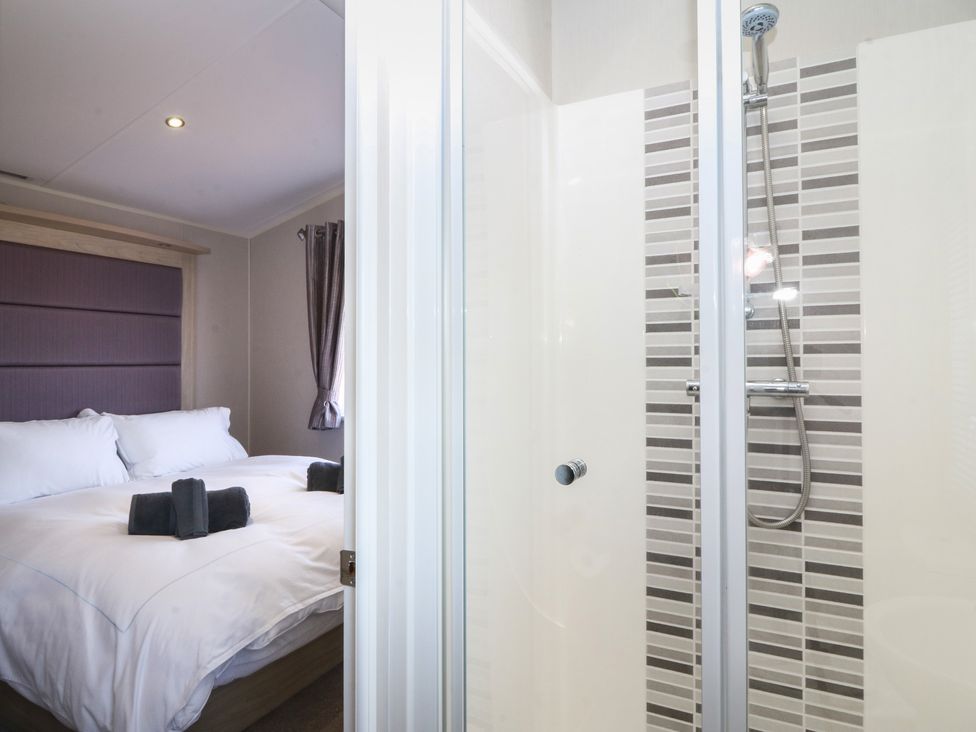 A bedroom with a shower and bed at Pheasant Lodge in Holyhead