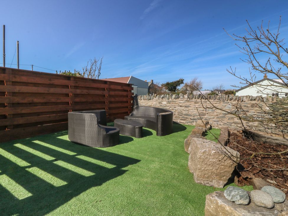A garden with seating and stone features at Pheasant Lodge in Holyhead