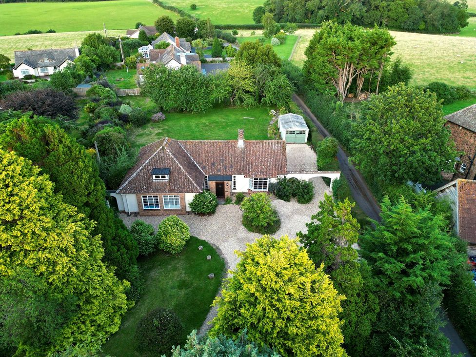An aerial view of a house with a garden and driveway at Barton Lodge in Porlock