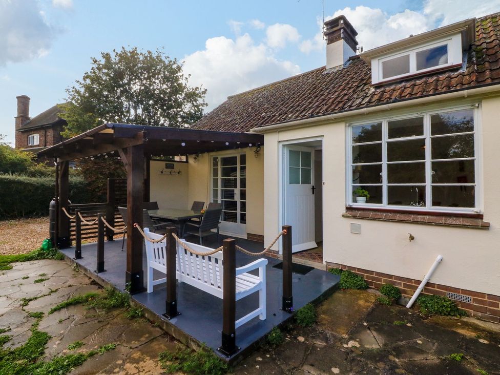 An outdoor patio with a table and chairs at Barton Lodge in Porlock