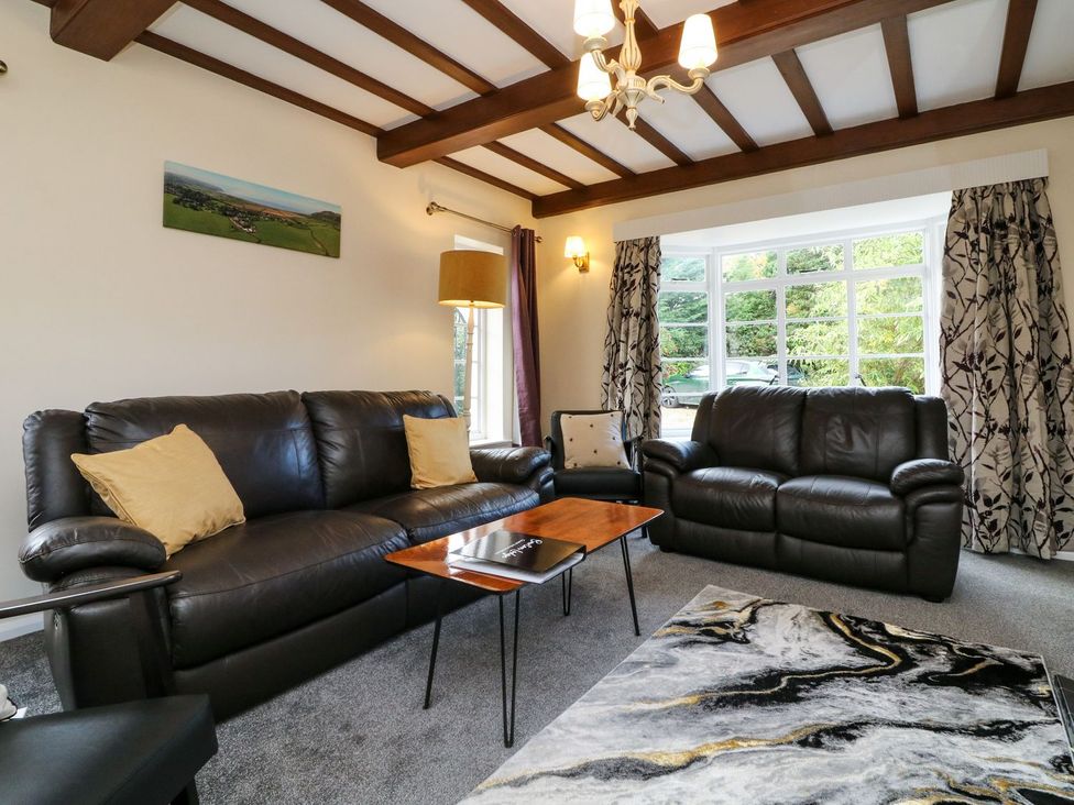 A living room with sofas and a table at Barton Lodge in Porlock
