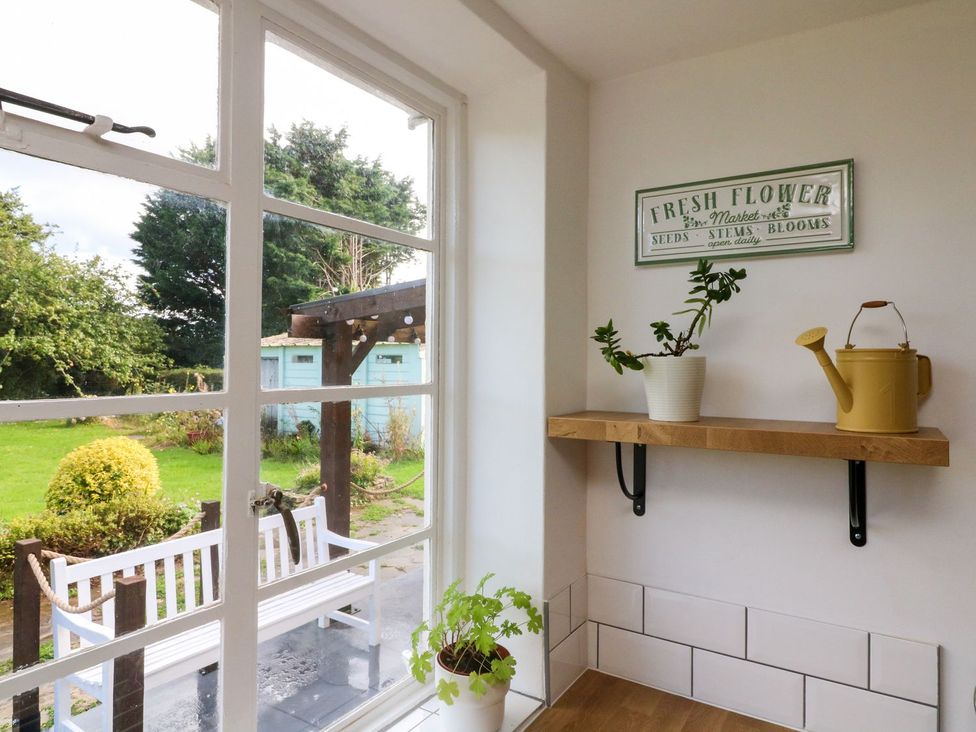 A kitchen with a window and shelf at Barton Lodge in Porlock
