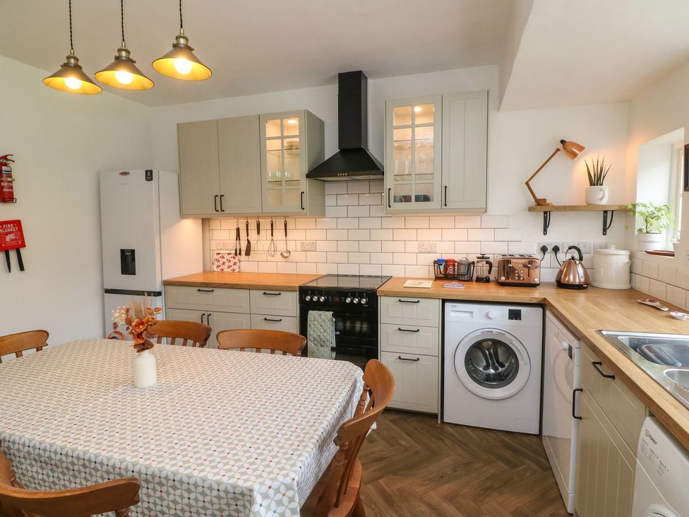 A kitchen with a table and chairs at Barton Lodge in Porlock