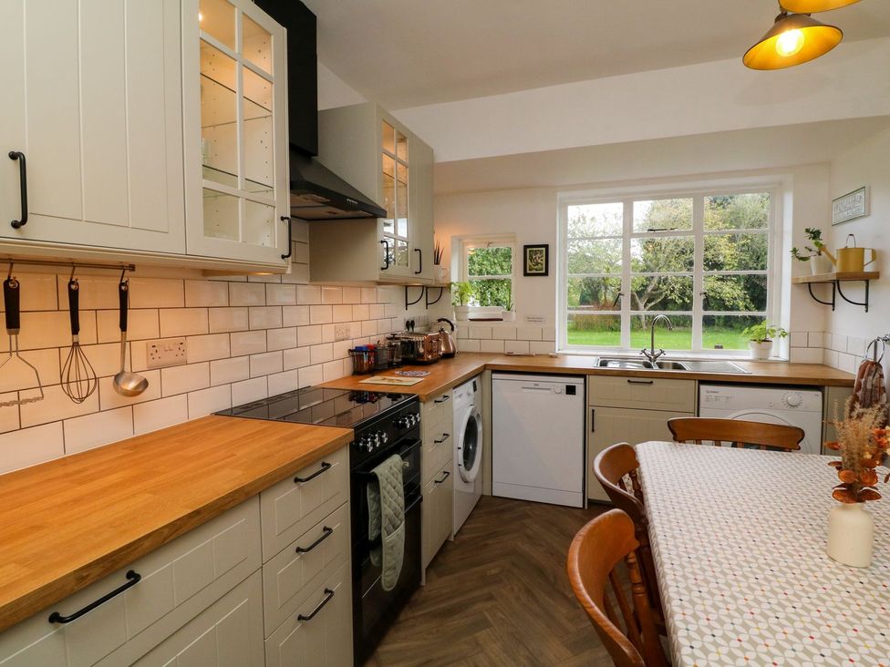 A kitchen with cabinets, a stove, and a sink at Barton Lodge in Porlock