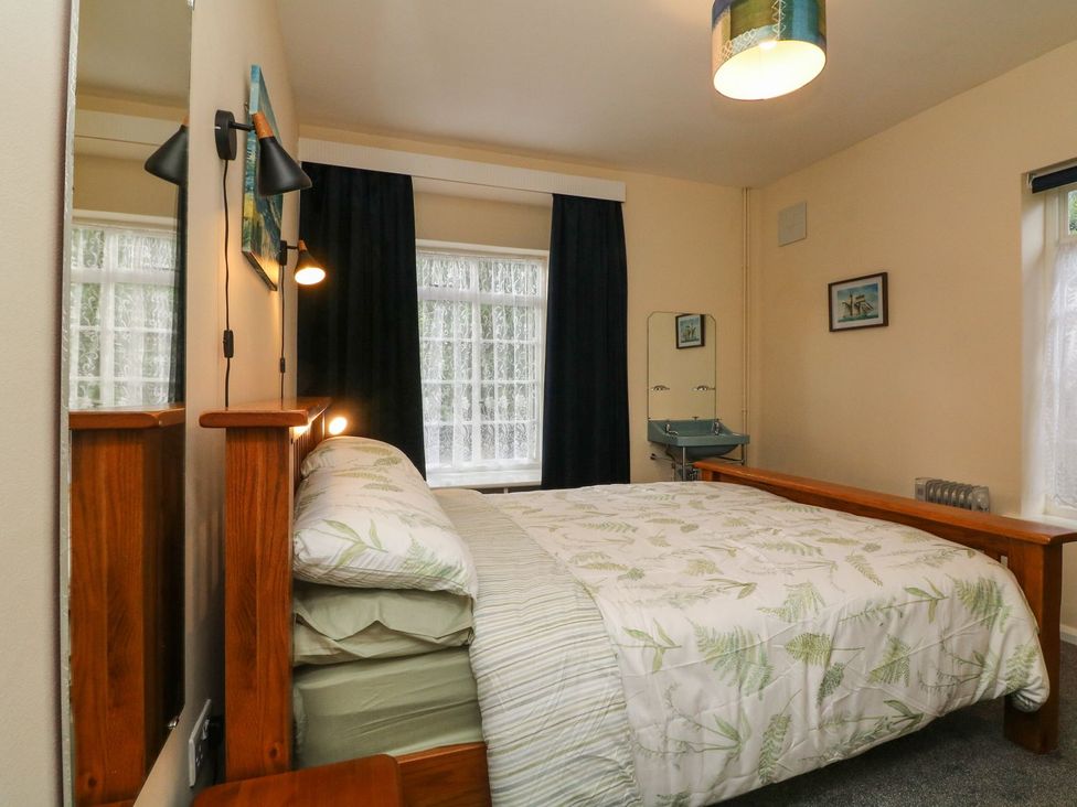 A bedroom with a bed and a washbasin at Barton Lodge in Porlock