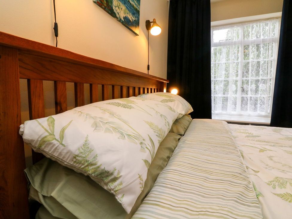A bed with pillows and a window at Barton Lodge in Porlock