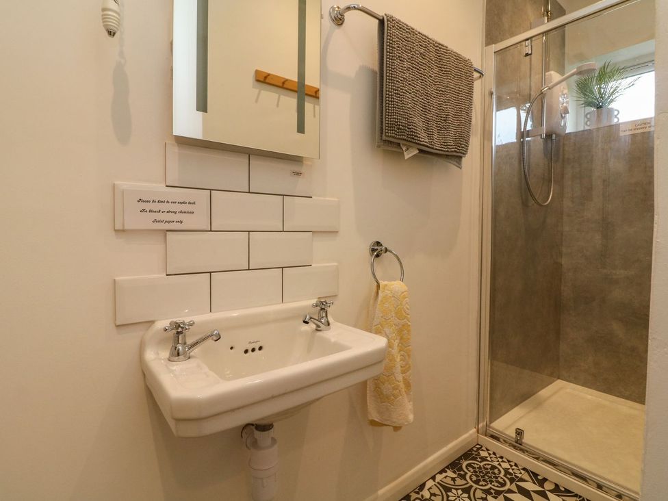 A bathroom with a sink and shower at Barton Lodge in Porlock