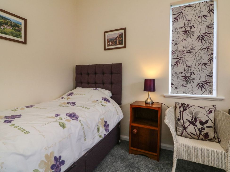 A bedroom with a bed and a bedside table at Barton Lodge in Porlock
