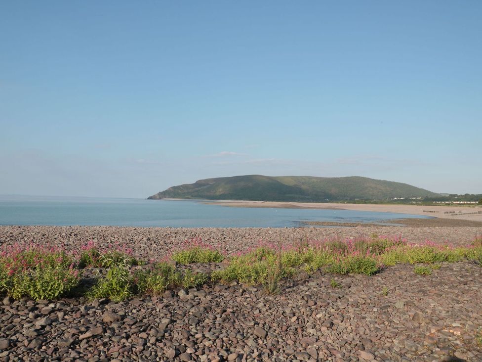 A beach view with rocks and flowers at Barton Lodge Porlock