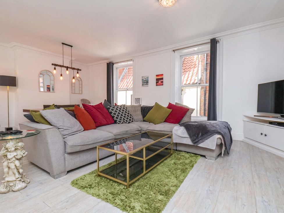 A living room with a sofa, coffee table, and television at The Four Views in Whitby