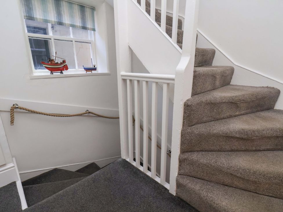 A staircase with a window and decorative boats at The Four Views in Whitby