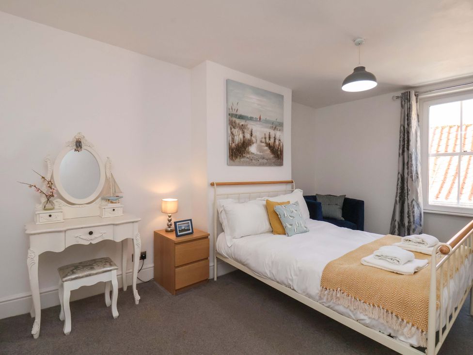 A bedroom with a bed and a mirror at The Four Views in Whitby