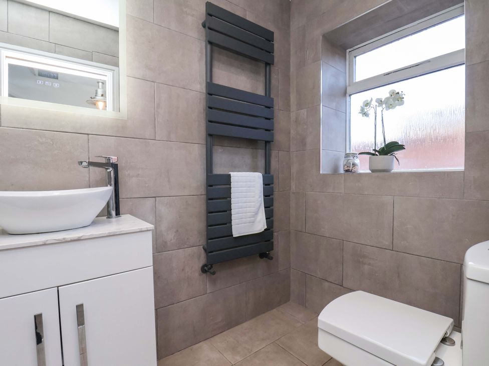 A bathroom with sink, towel rail, toilet and window at The Four Views in Whitby