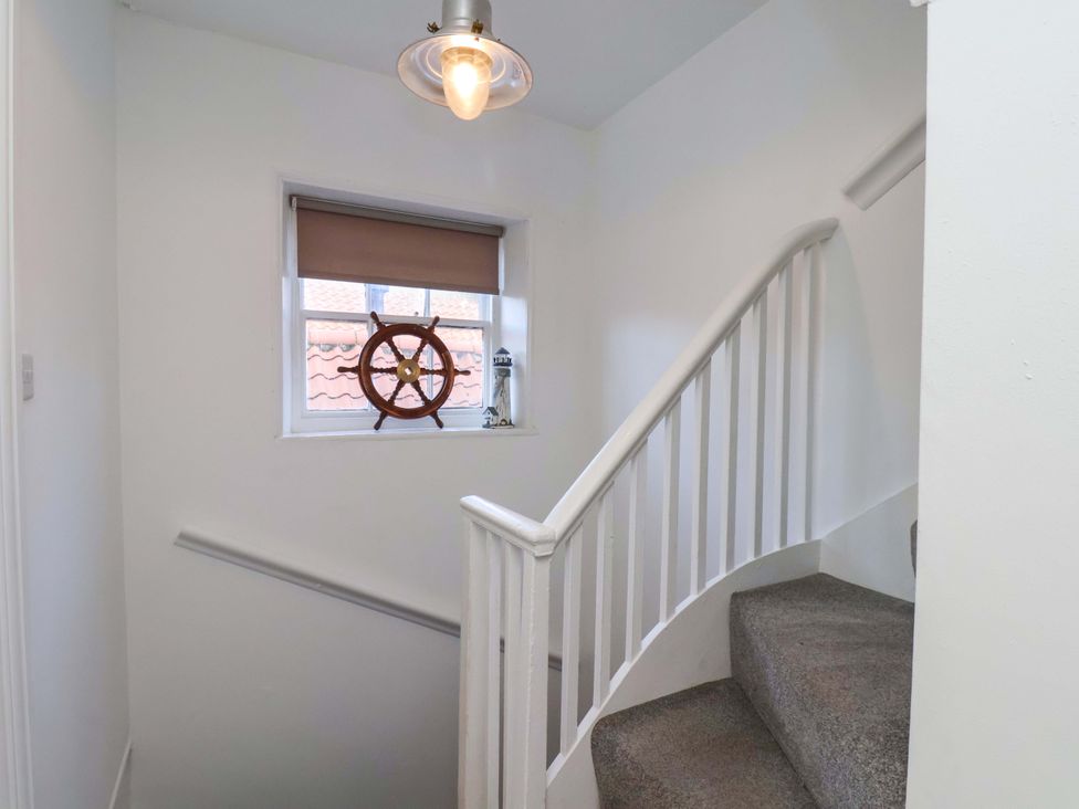 A staircase with a window and light fixture at The Four Views in Whitby
