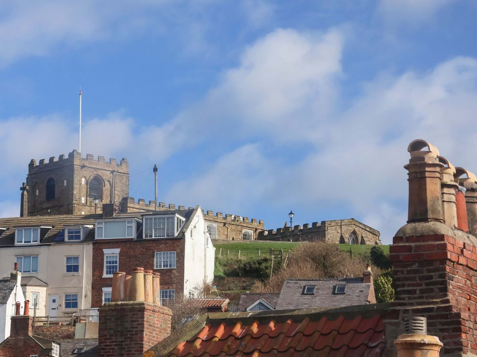A castle is visible above rooftops in Whitby