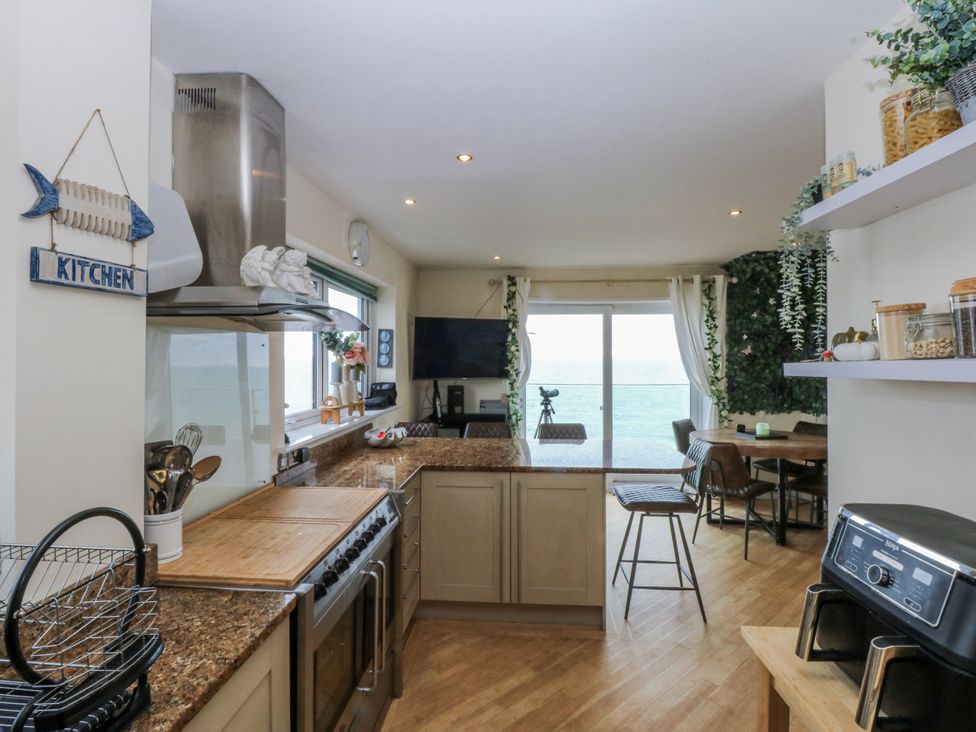 A kitchen with an oven and a table by a window at Snowdonia View in Pwllheli