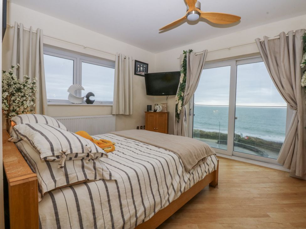 A bedroom with a bed and ocean view at Snowdonia View in Pwllheli