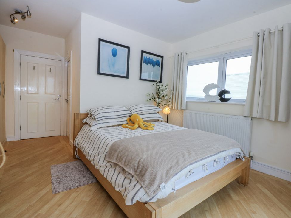A bedroom with a bed and pictures on the wall at Snowdonia View in Pwllheli
