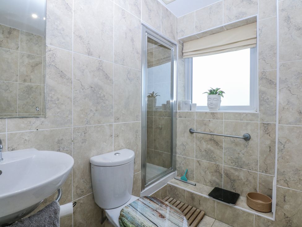 A bathroom with a sink, toilet, and shower at Snowdonia View in Pwllheli