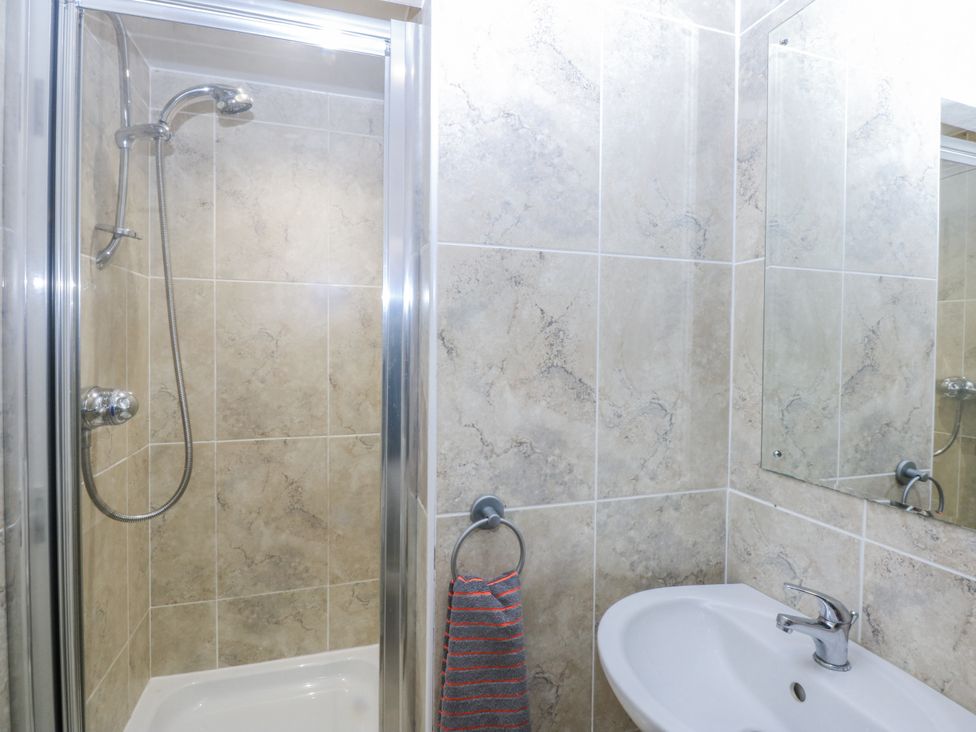 A bathroom featuring a shower, sink, and mirror at Snowdonia View in Pwllheli